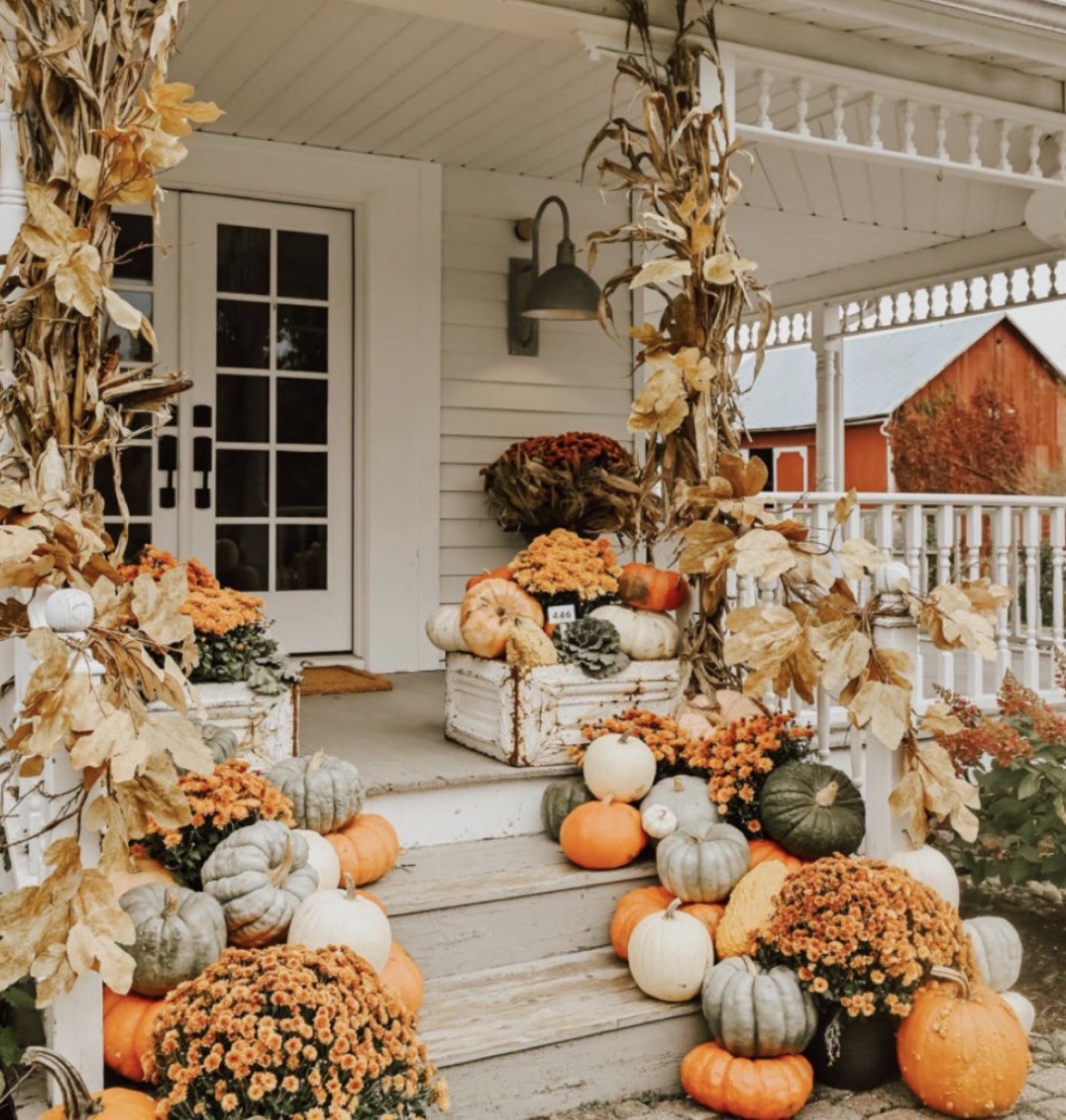 New England fall porch styled by Clifford's Pumpkins with heirloom pumpkins, mums, and lanterns